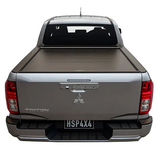 Back view of a silver Mitsubishi Triton pickup truck with a tonneau cover on a white background