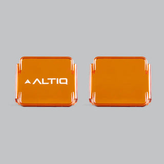 Two amber DX4 lens covers side by side against grey, the left one carrying the ALTIQ name and the right one plain