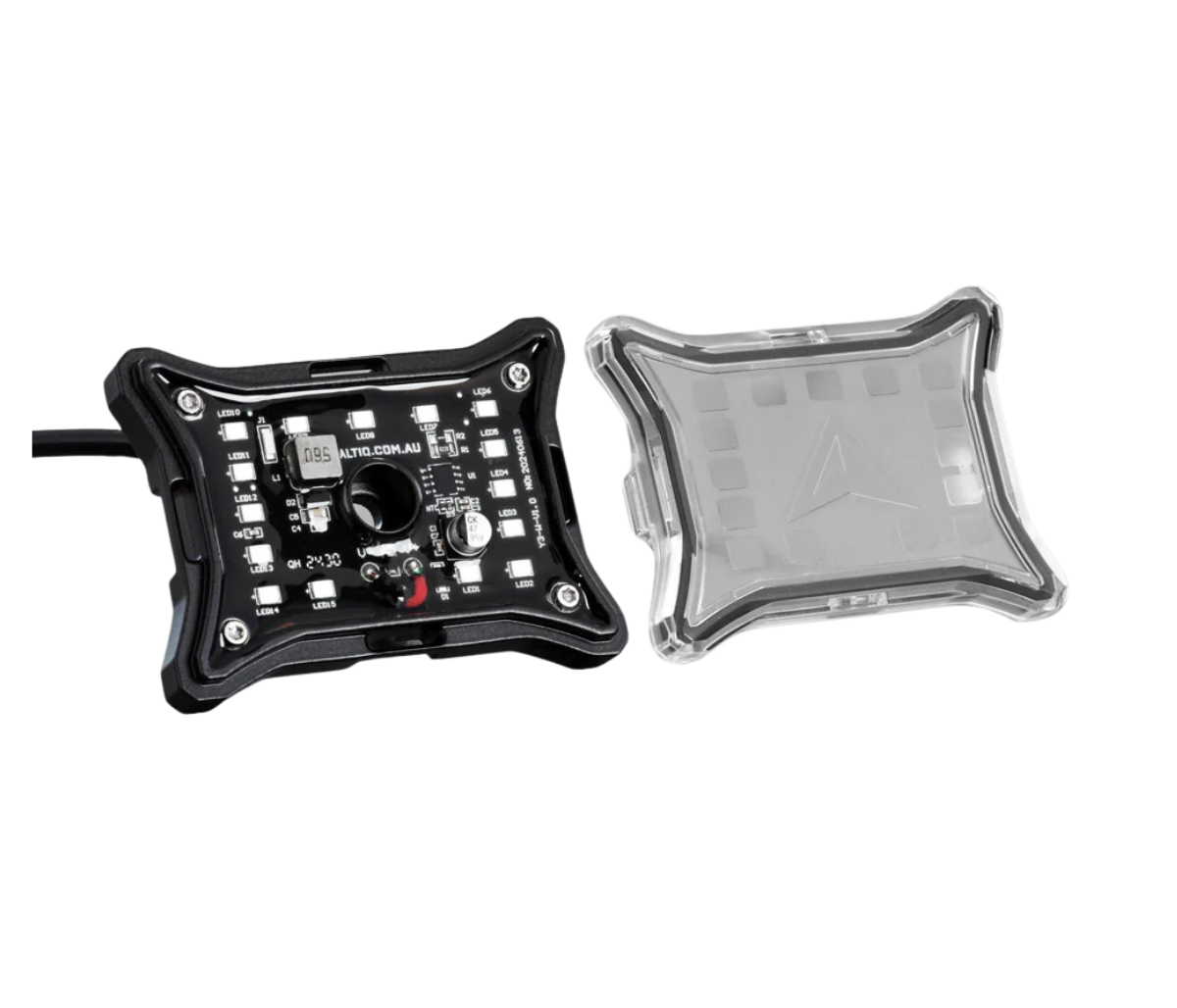 The rock light shown in two parts, the LED board in its black frame with the lead attached beside the clear lens cover that clips over it