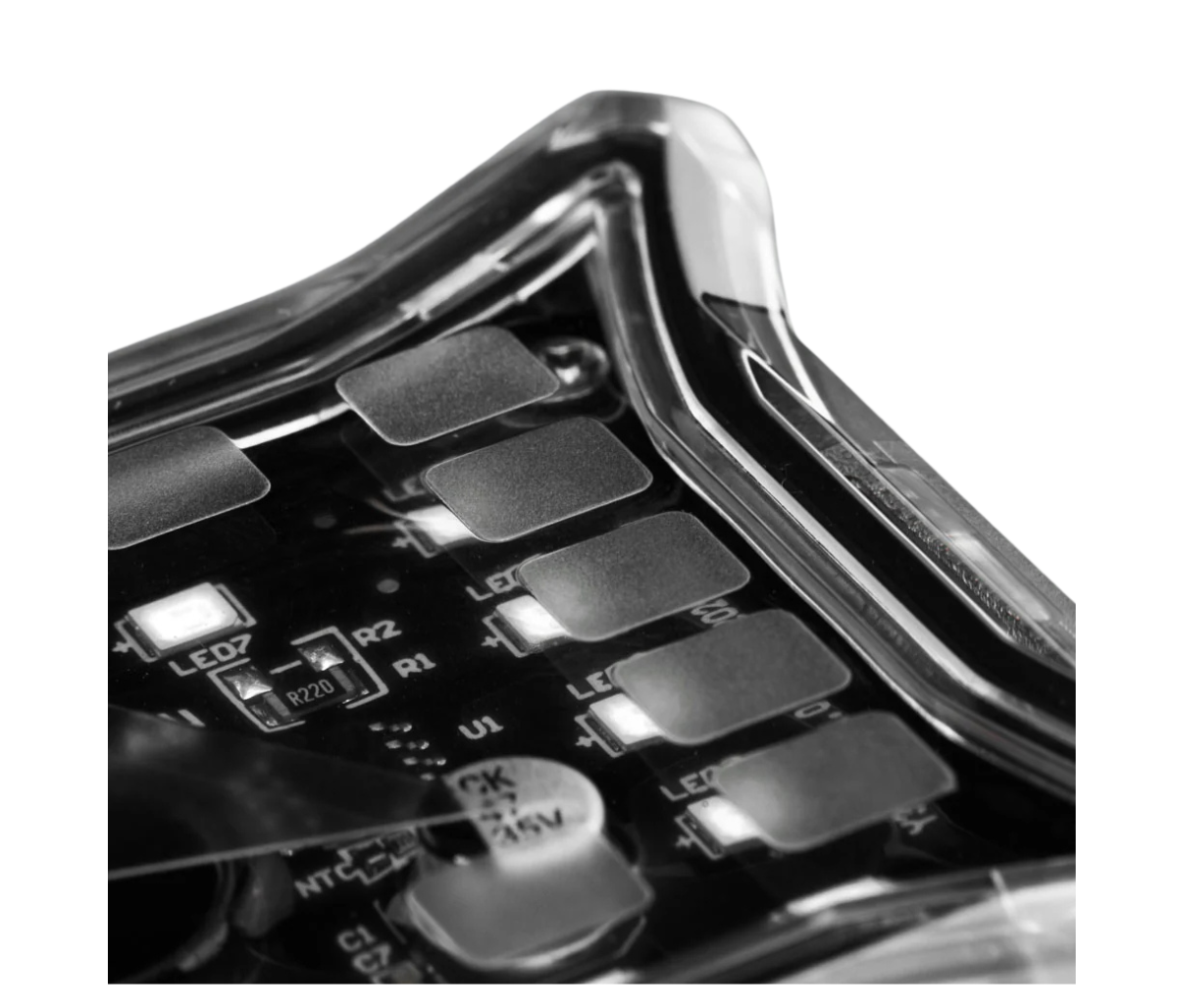 Close-up inside an ALTIQ Spectrum Pro rock light, the clear lens over the circuit board with its surface-mount LEDs, the numbered LED positions and the electrolytic capacitor rated 47 microfarads at 35 volts