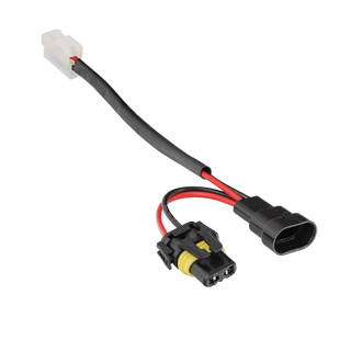 Halogen high beam piggy-back adaptor laid out, a white two-pin plug at one end and at the other a black male connector and a yellow-locked female connector on short red and black tails