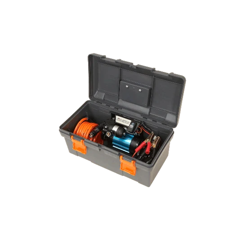 ARB single piston compressor packed inside its grey travel case, the orange air hose coiled beside the compressor and the battery clamps stowed alongside, with the lid propped open