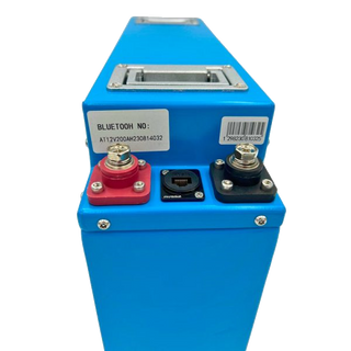 Top of the slimline battery showing the recessed carry handle, the red and black terminal blocks with their stainless bolts, and the sealed communication socket between them, with the Bluetooth serial number sticker alongside