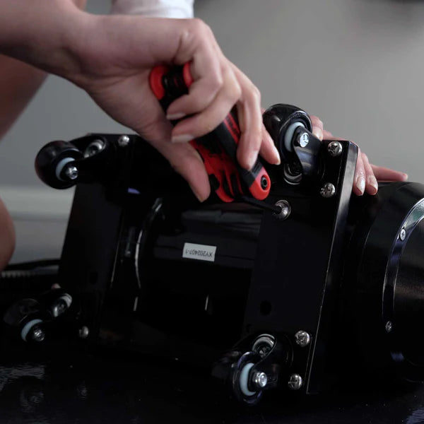 Close-up of hands removing bolts from the Blahst Air Maxx dryer