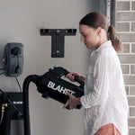 Woman using a Blahst airmax dryer against a gray wall.
