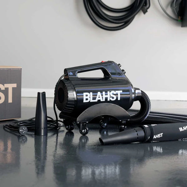 Black Blahst Air Maxx Dryer on a reflective surface with a white wall in the background