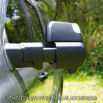 Close-up of a vehicle with black side mirrors against a natural background