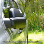 Car side mirror with black finish on a vehicle, outdoors.