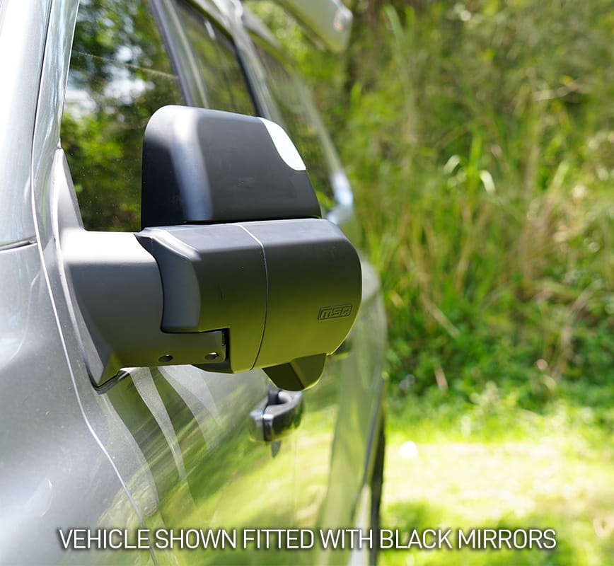 Car side mirror with black finish on a vehicle, outdoors.