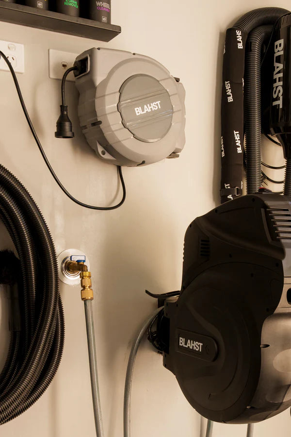 Blast brand extension cord reel and tools mounted on a wall.