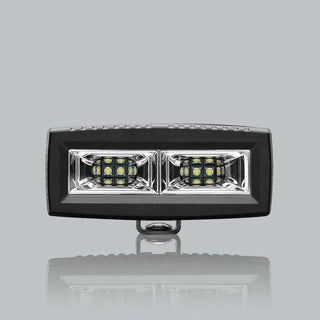 ALTIQ CX4 scene work light square on, a wide rectangular lens holding two reflector segments each with a dense cluster of LEDs, in a black housing with the mounting bracket beneath
