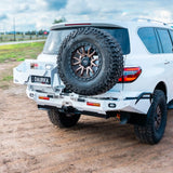 White SUV with spare tire mounted on a dirt road