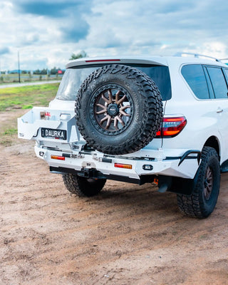 White SUV with spare tire mounted on a dirt road