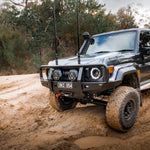 Toyota SUV driving on a dirt road with trees in the background