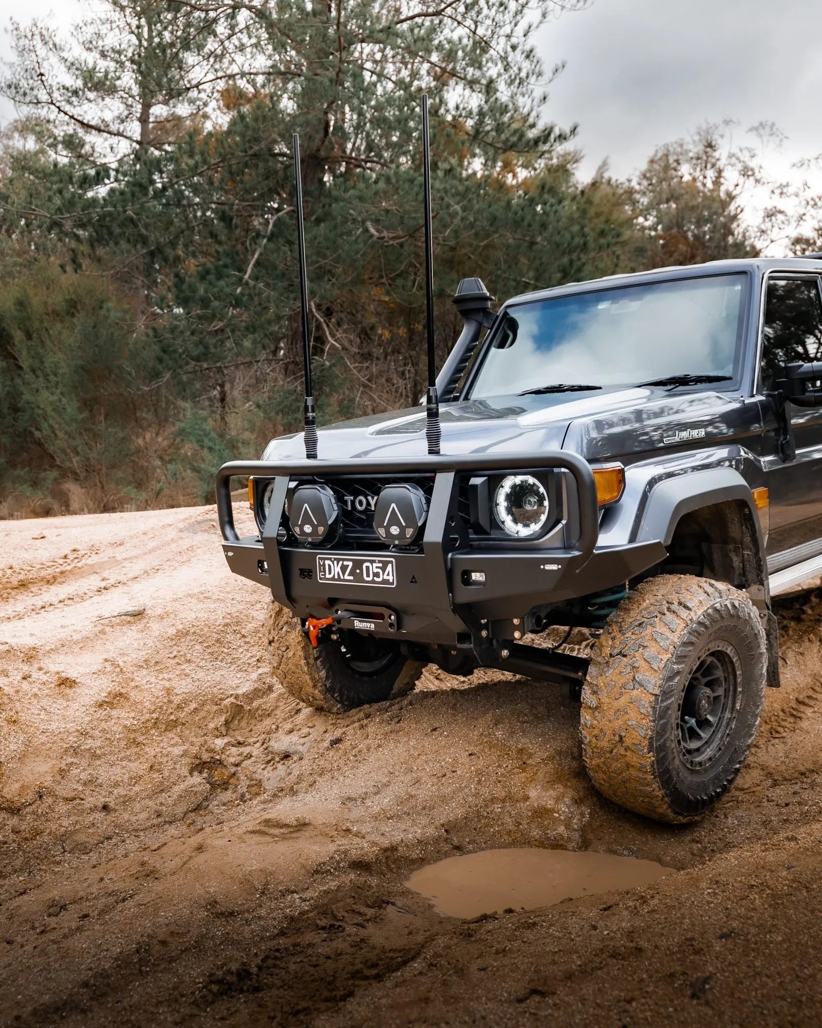Toyota SUV driving on a dirt road with trees in the background
