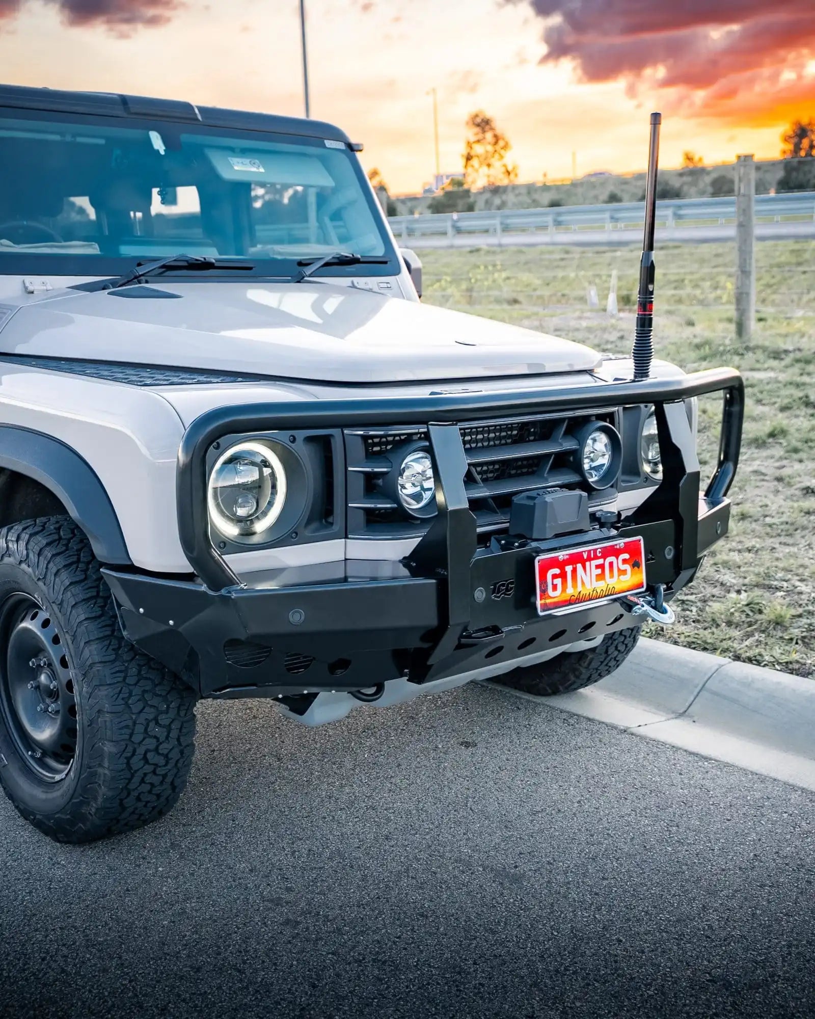 White off-road vehicle with a sunset in the background