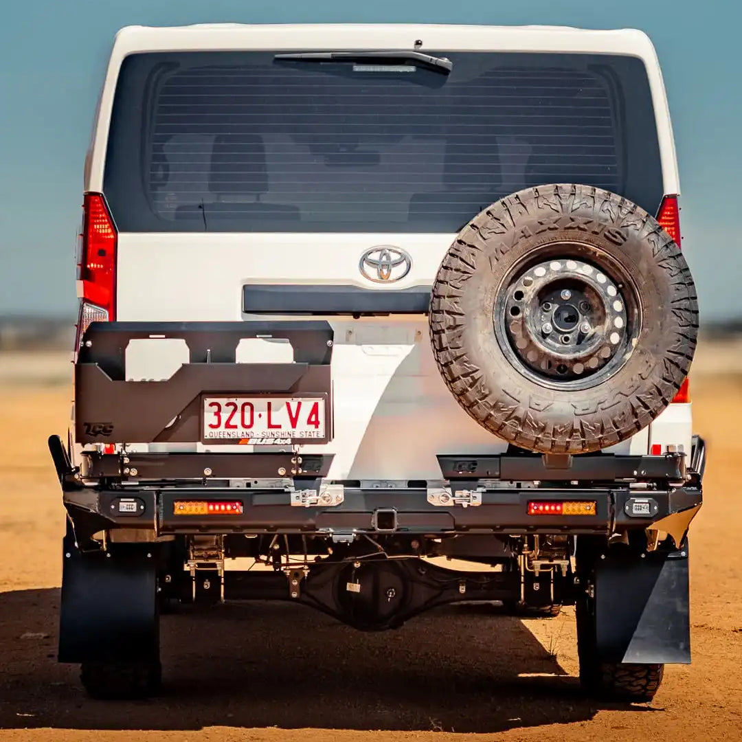 Back view of a white Toyota vehicle with a spare tire on a desert landscape