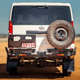 Back view of a white Toyota vehicle with a spare tire on a desert landscape