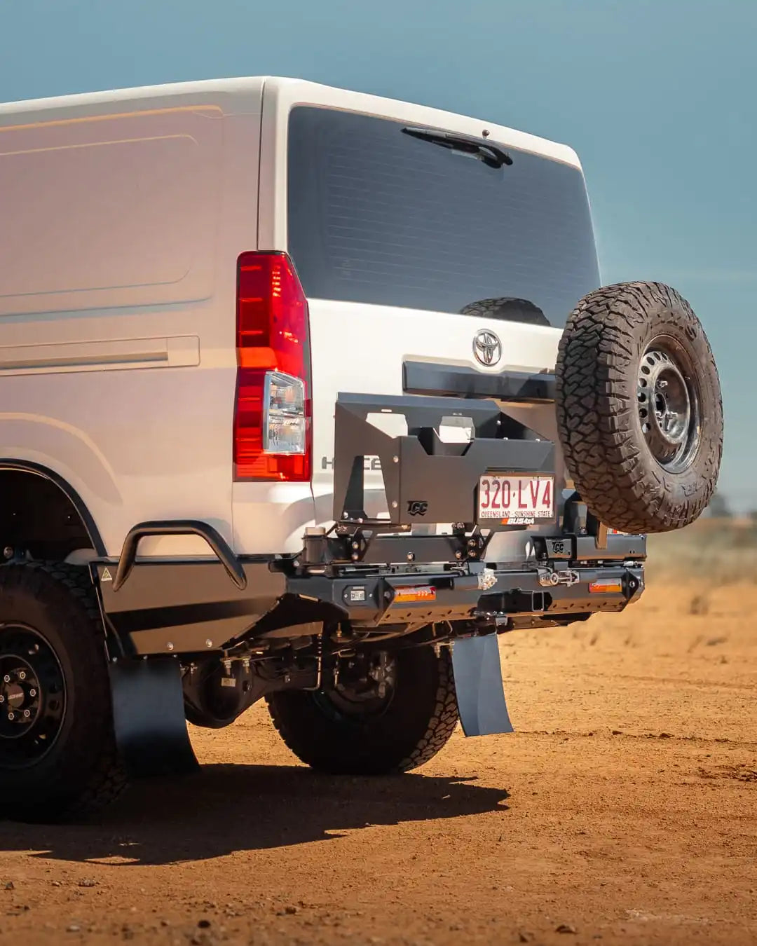 White van with a spare tire mounted on the back in a desert setting
