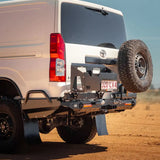 White van with a spare tire mounted on the back in a desert setting