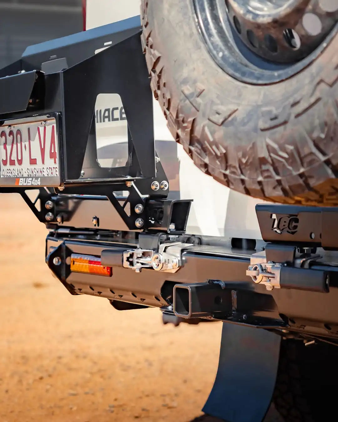 Close-up of a vehicle's hitch receiver with a tire in the background