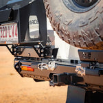 Close-up of a vehicle's hitch receiver with a tire in the background