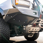 Close-up of a vehicle's front bumper and tire on a road