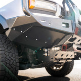 Close-up of a vehicle's front bumper and tire on a road