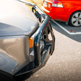 Close-up of a car bumper with another car partially visible in the background.
