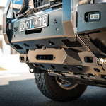 Close-up of a vehicle's front bumper with visible branding and license plate.