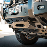 Close-up of a vehicle's front bumper with visible branding and license plate.