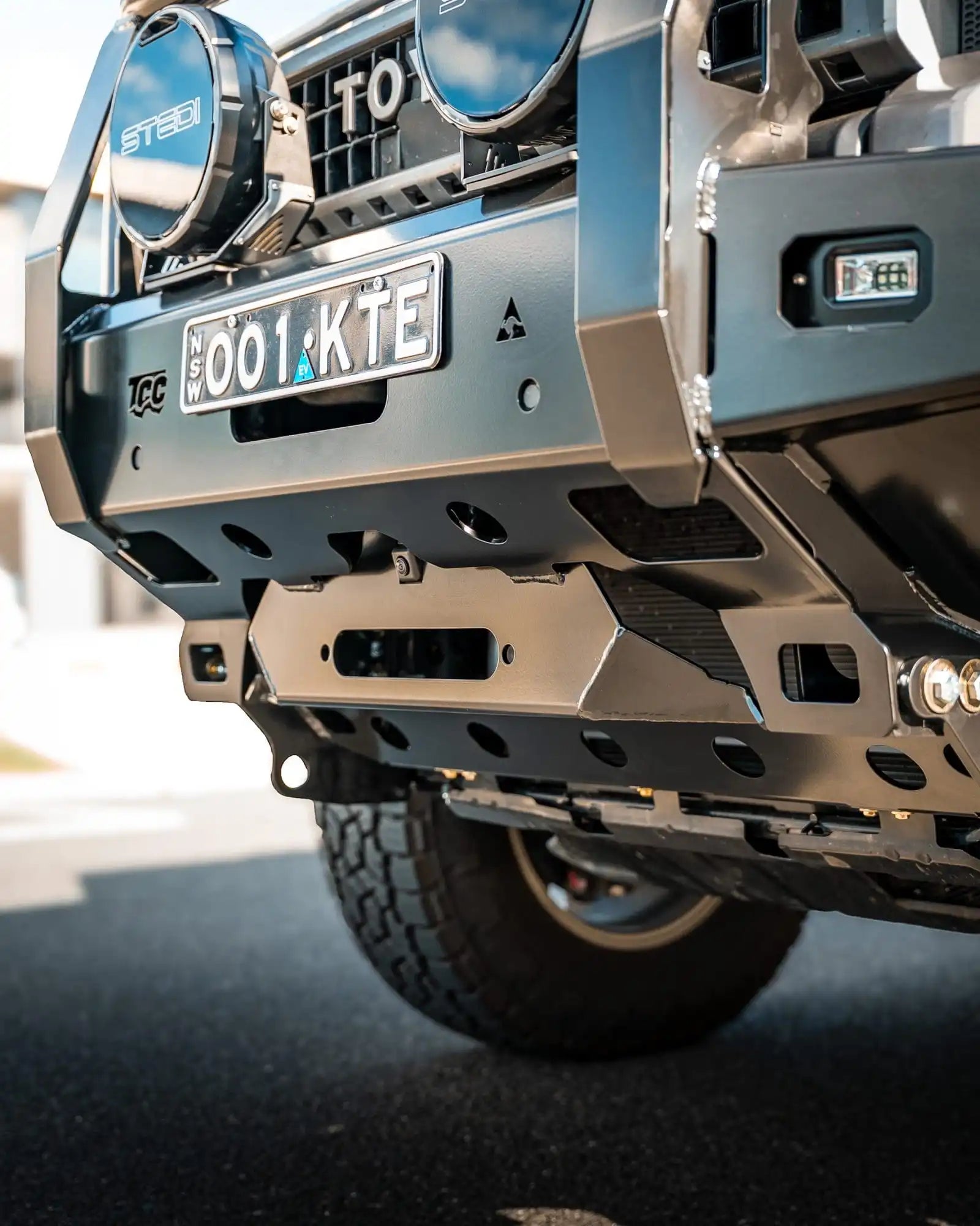 Close-up of a vehicle's front bumper with visible branding and license plate.