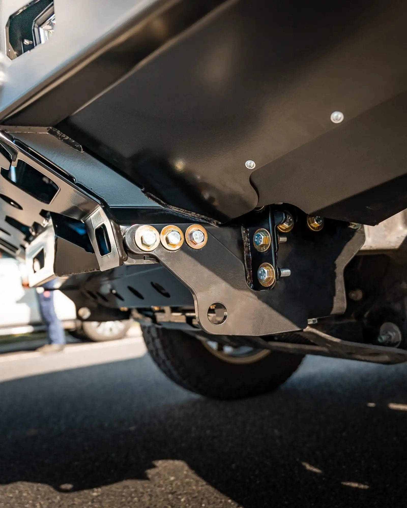 Close-up of a vehicle's undercarriage with visible suspension components on a road.