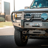 Front view of a Toyota vehicle with a grille guard on a road.