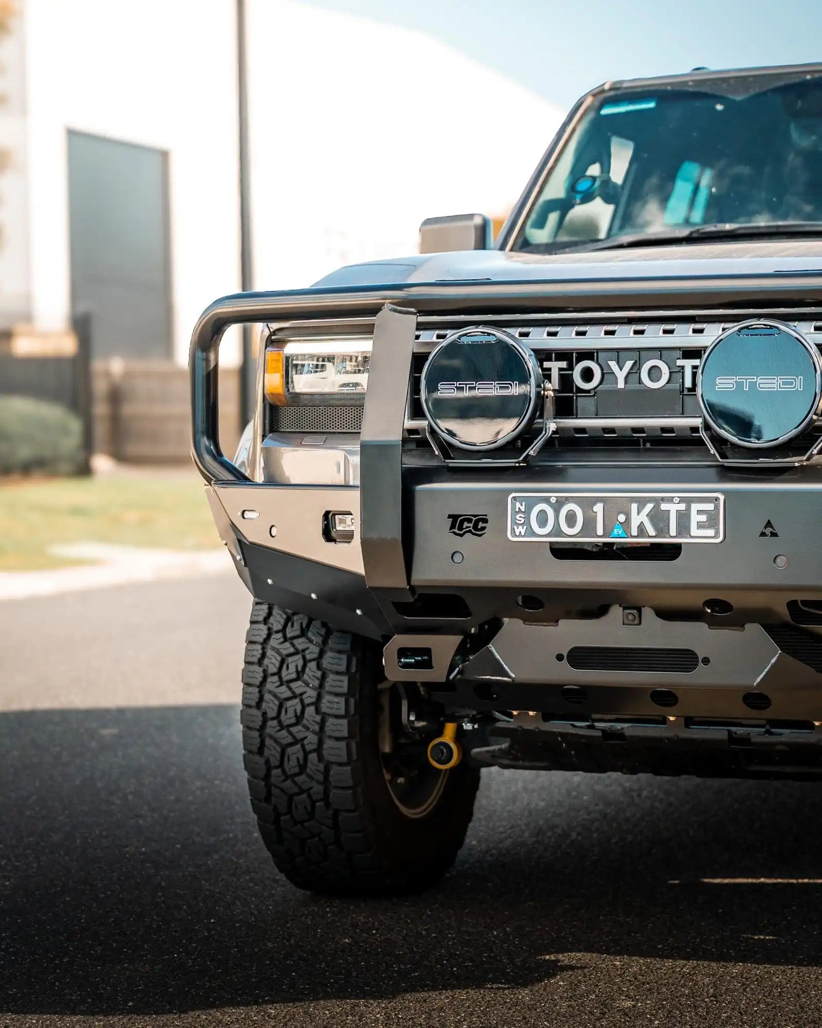 Front view of a Toyota vehicle with a grille guard on a road.