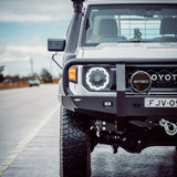 White off-road vehicle with custom modifications on a road