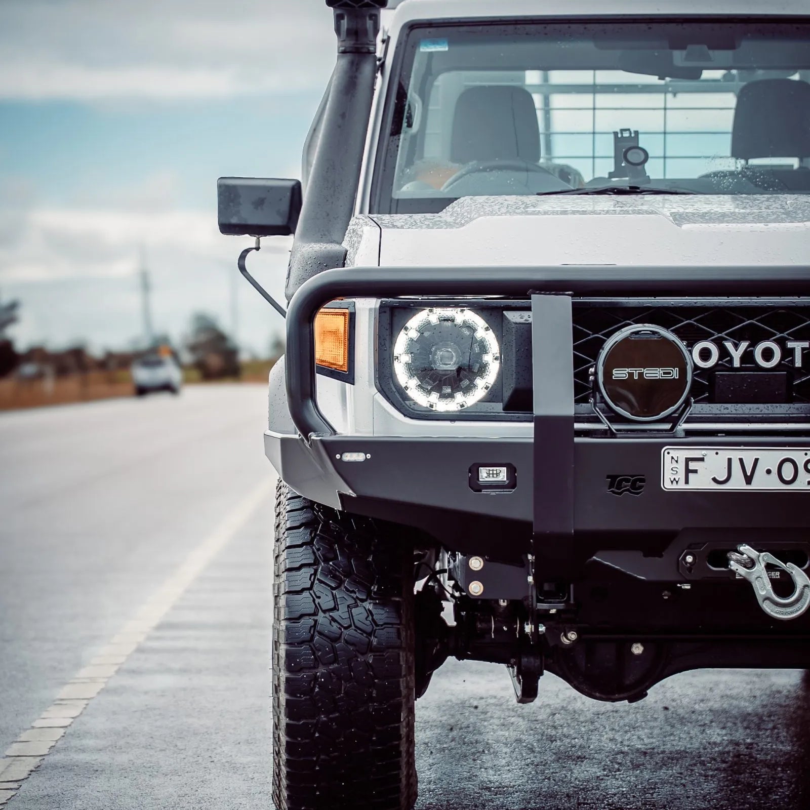 White off-road vehicle with custom modifications on a road