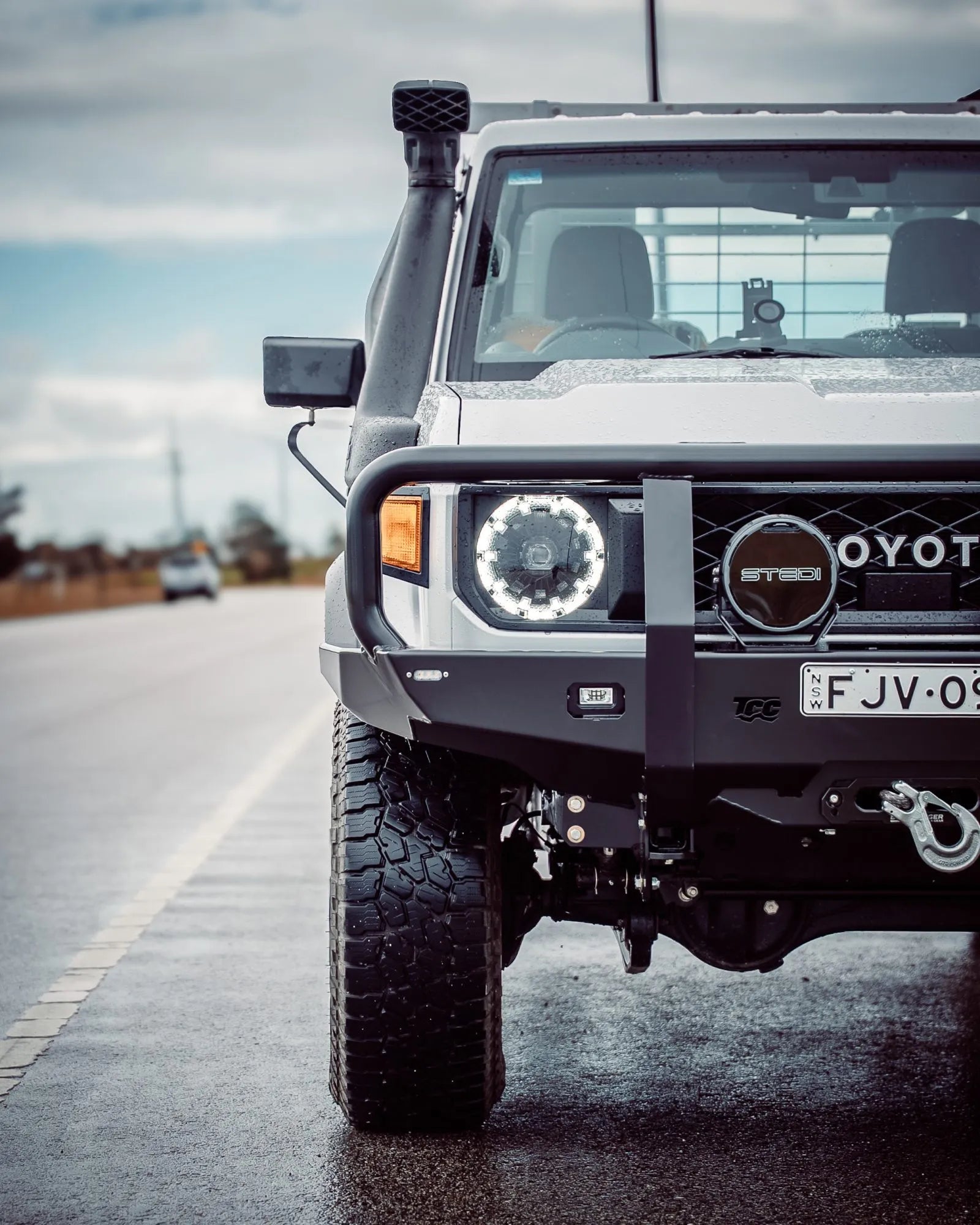 White off-road vehicle with custom modifications on a road