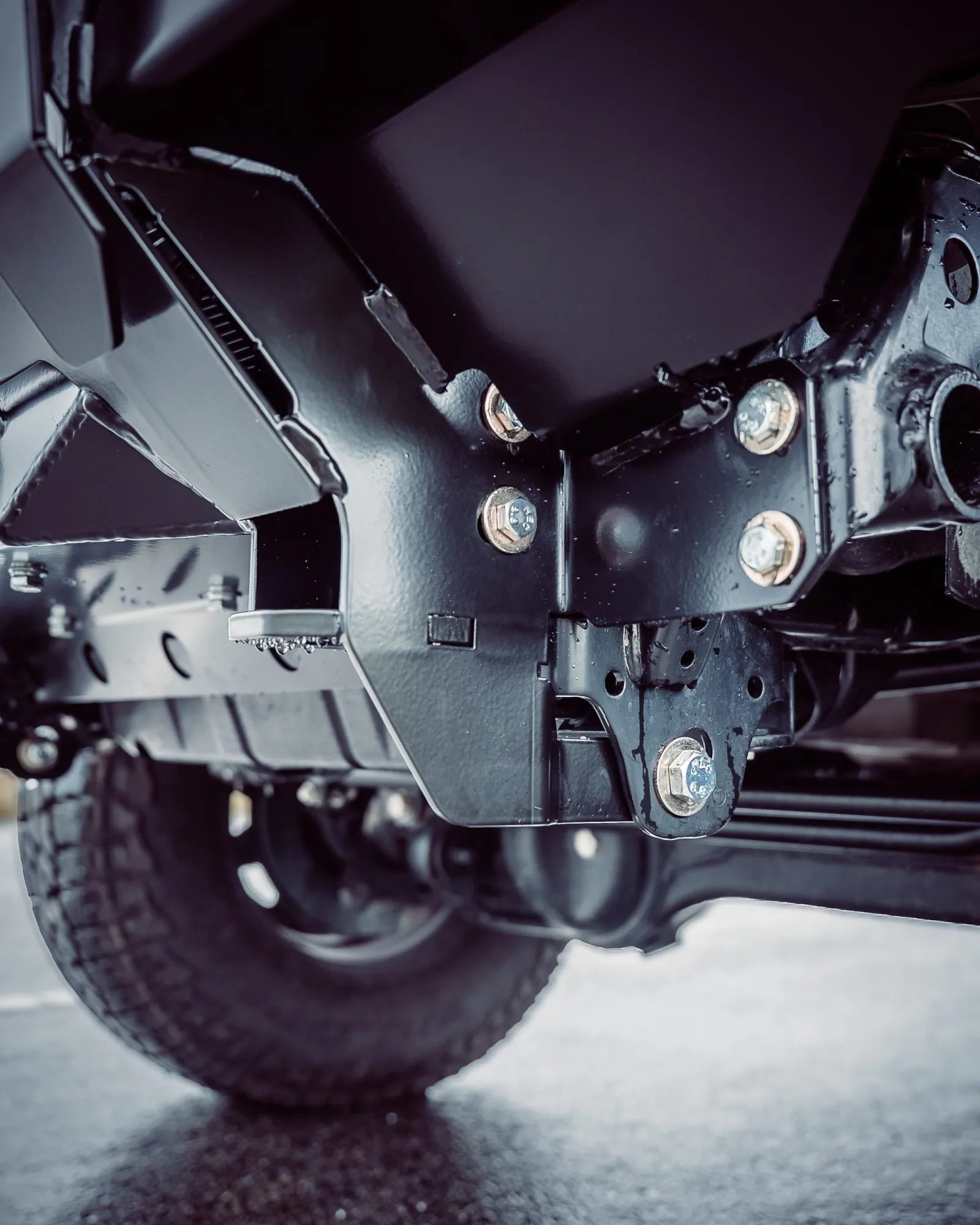 Close-up of a black LC70 suspension system on a road.