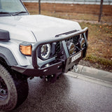 White off-road vehicle on a road with a rural landscape in the background