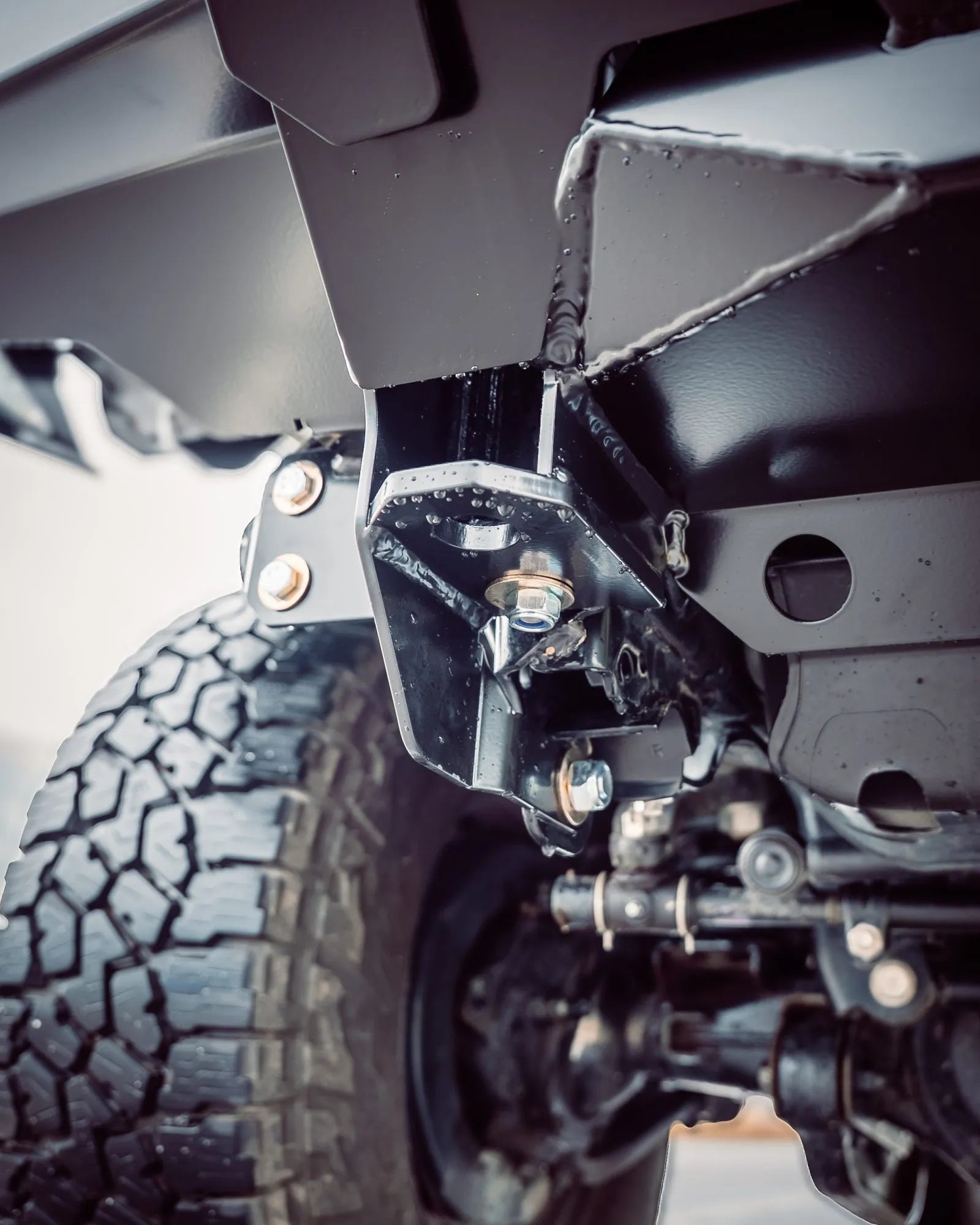 Close-up of a vehicle's suspension system with tire and undercarriage details.