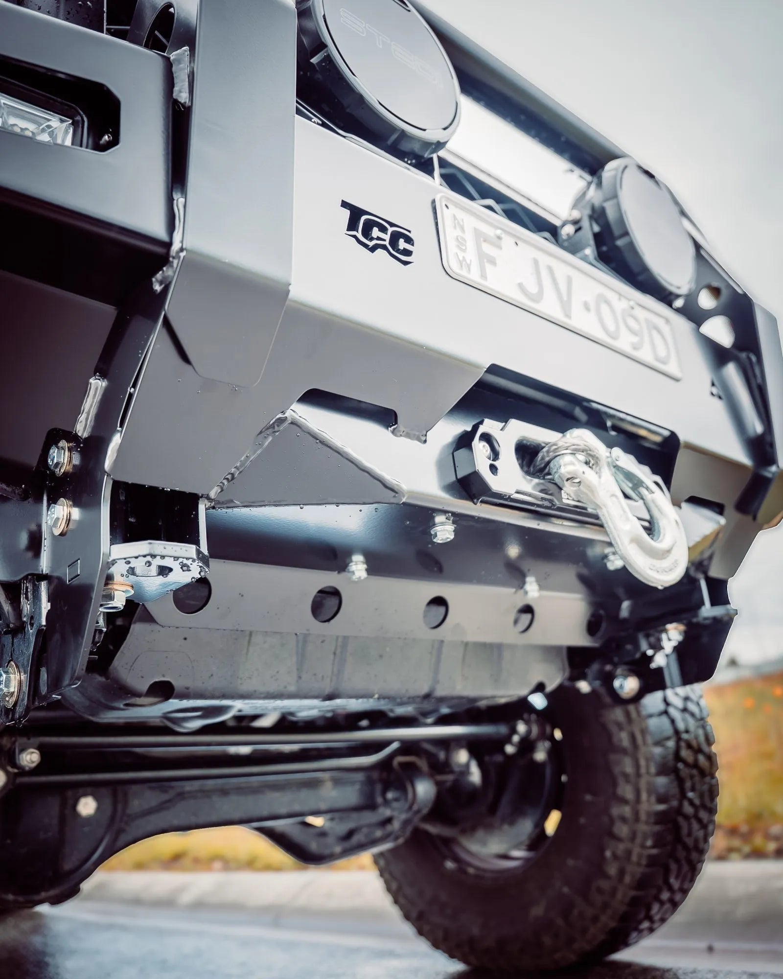 Close-up of a vehicle's front bumper with TCC branding and license plate.