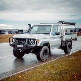 White Toyota truck on a wet road with a cloudy sky