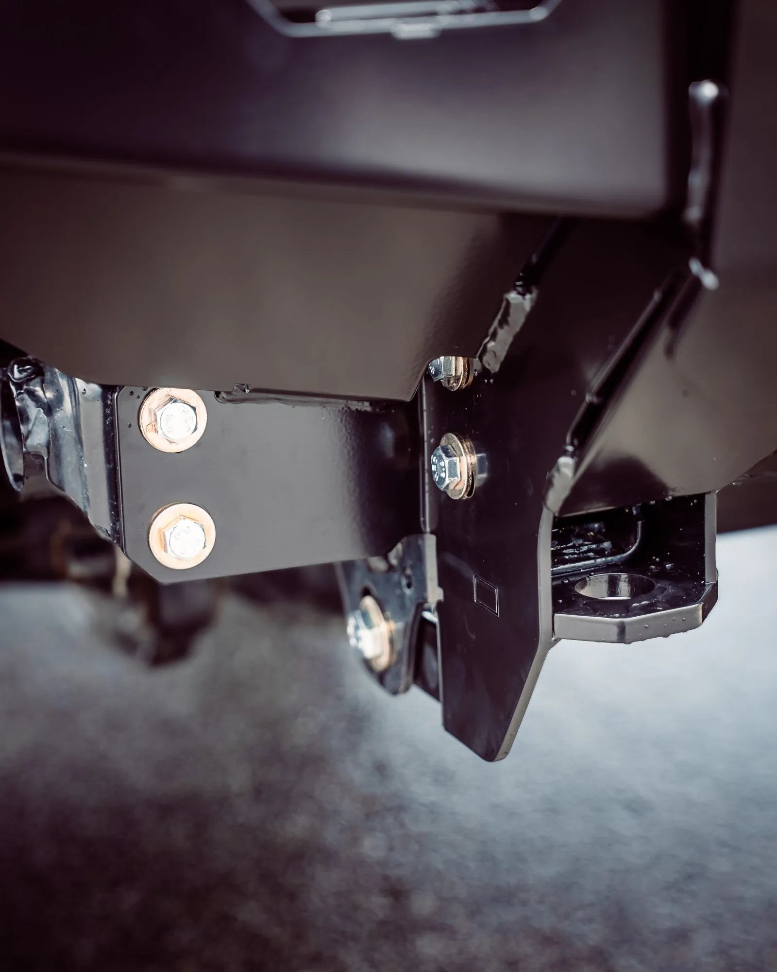 Close-up of a metal bracket with screws on a dark background