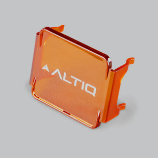 Amber DX4 lens cover tilted forward, showing the depth of the side skirts and the four retaining clips that hook over the light