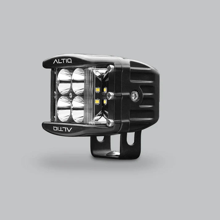 DX4 hybrid work light turned further round, the four spot reflectors and the amber-tinted side flood LEDs both visible with the ALTIQ name on the bezel