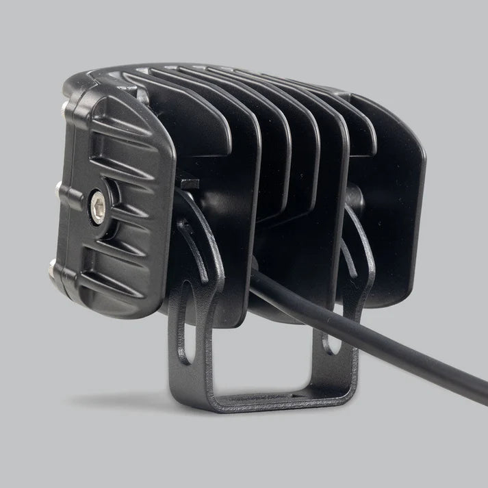 DX4 hybrid work light from behind and to the side, the deeply finned cast heatsink, the black mounting bracket and the lead leaving the rear