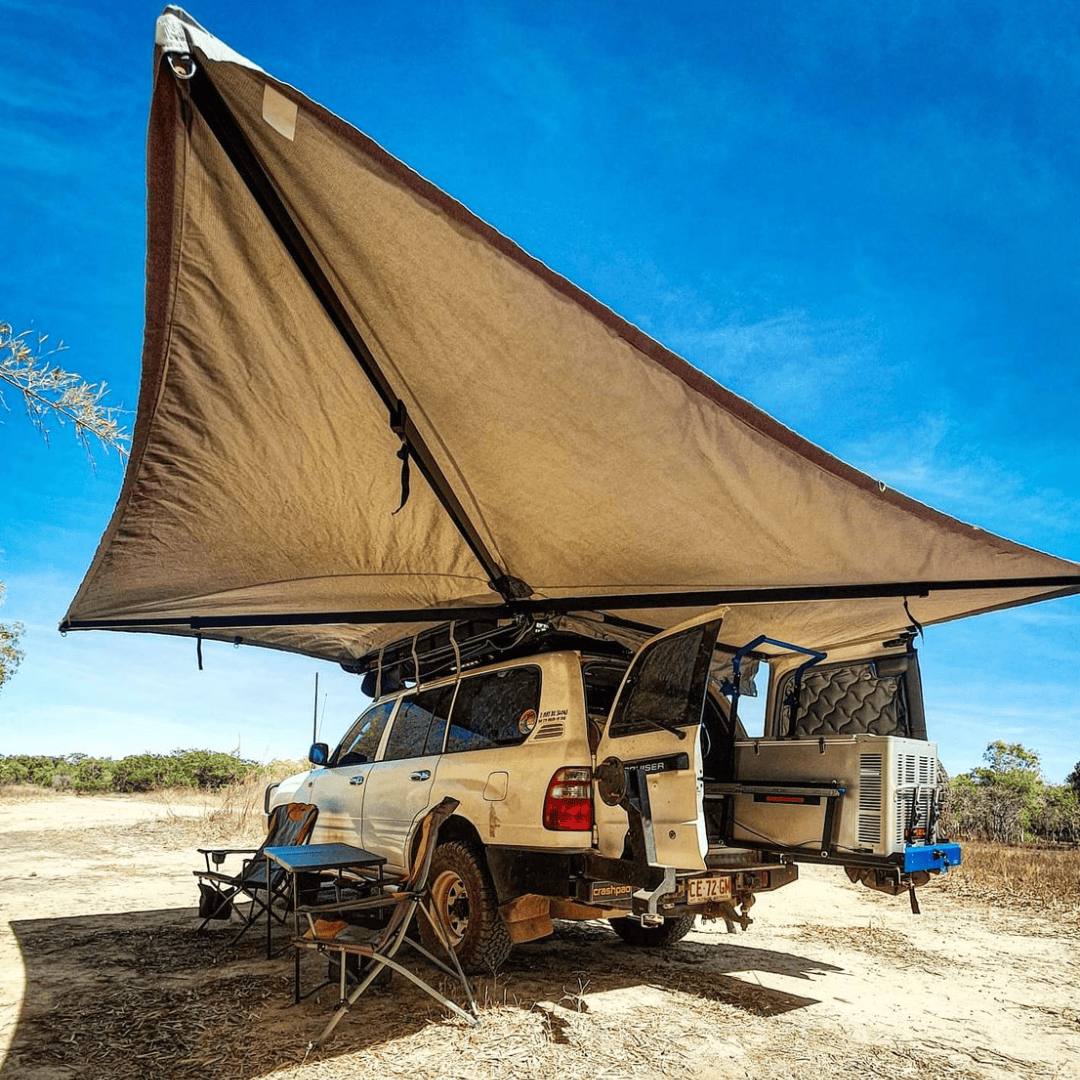 Camper van with an extended roof tent in a desert setting