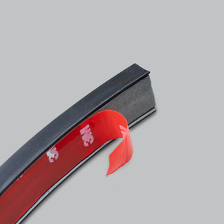 End of the wire concealer with the red 3M adhesive backing tape partly peeled away from the underside of the black moulded channel