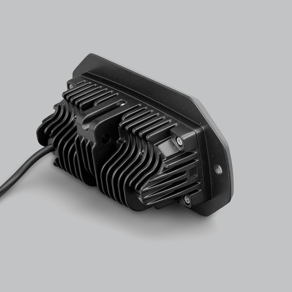 Rear of the CX4 flush mount light, showing the deep finned heatsink behind the mounting flange, the retaining screws and the cable leaving the back